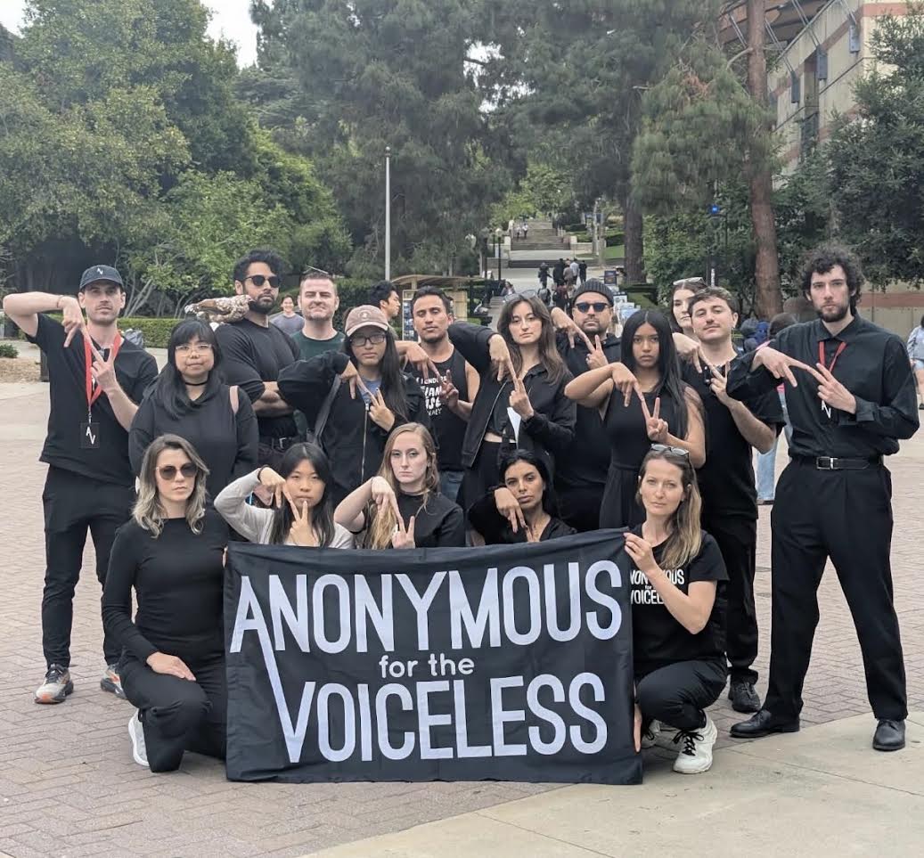 Group of activists holding an Anonymous for the Voiceless banner on campus